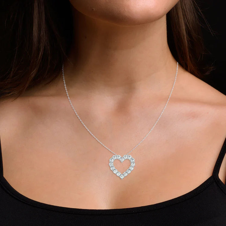 Heart-shaped diamond necklace on a model against a dark background