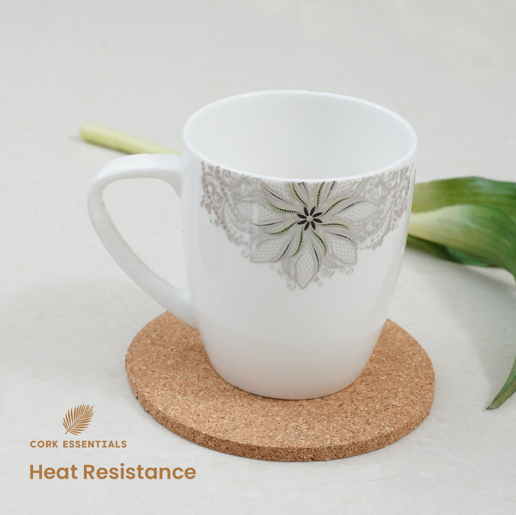 White mug with floral design on a cork coaster, featuring Cork Essentials branding.