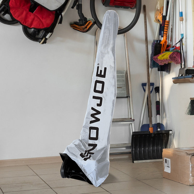 A white snowmobile cover with the brand name 'NOWJOE' printed vertically in black, leaning on a tiled floor in a garage setting.