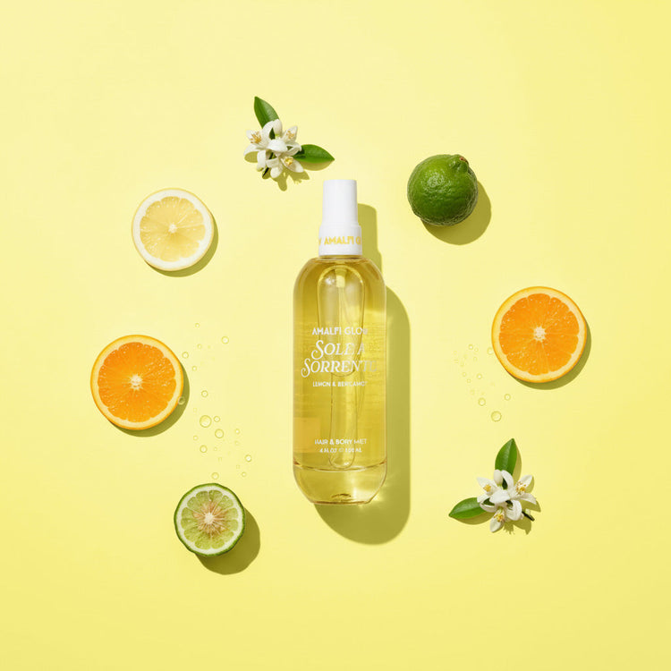 Spray bottle with lemon, lime, and orange slices on a yellow background
