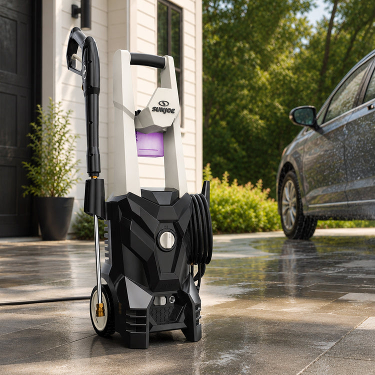 Sun Joe pressure washer in front of a house with a car in the background