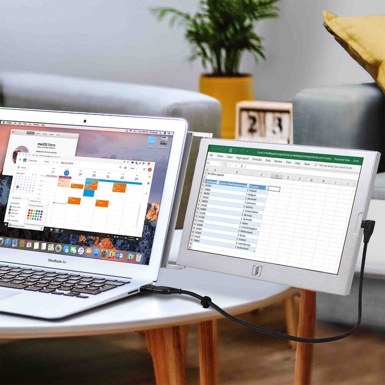 Laptop connected to a monitor displaying two open applications on a table in a home setting.