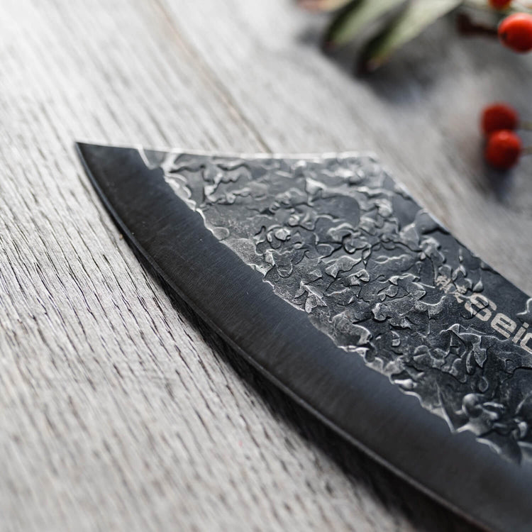 Serrated knife with floral patterns on a wooden surface