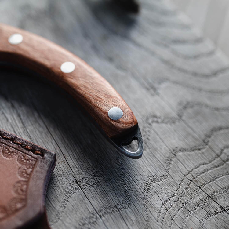 Wooden tool with metal tip on a textured wooden surface