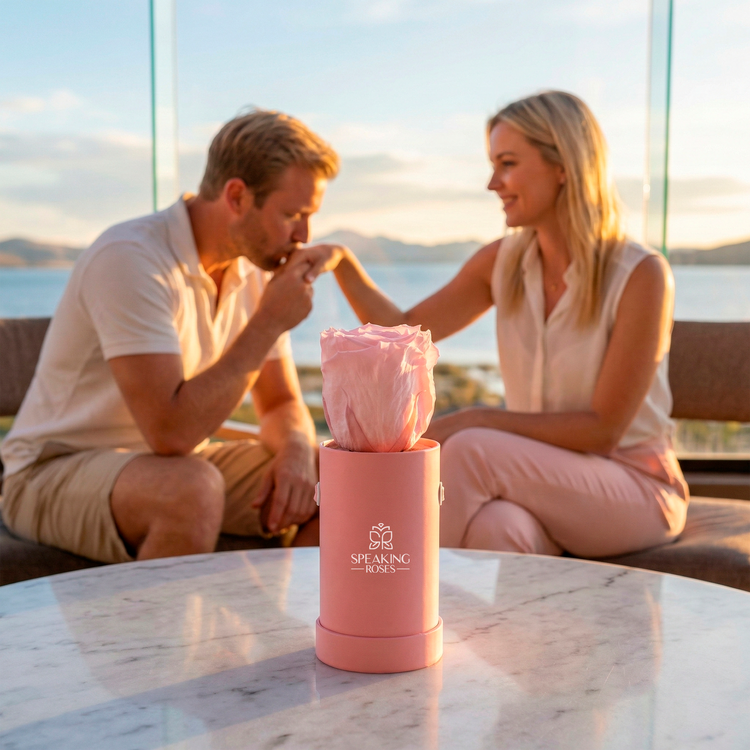 Couple sitting outdoors with a pink 'Speaking Roses' container on a table