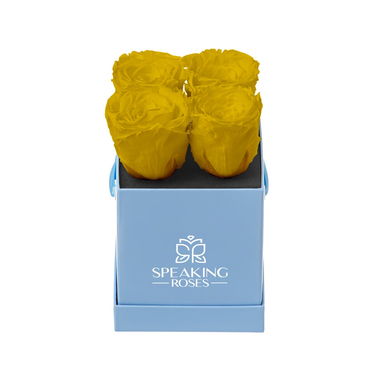 Three yellow roses in a blue box with 'Speaking Roses' logo on a white background