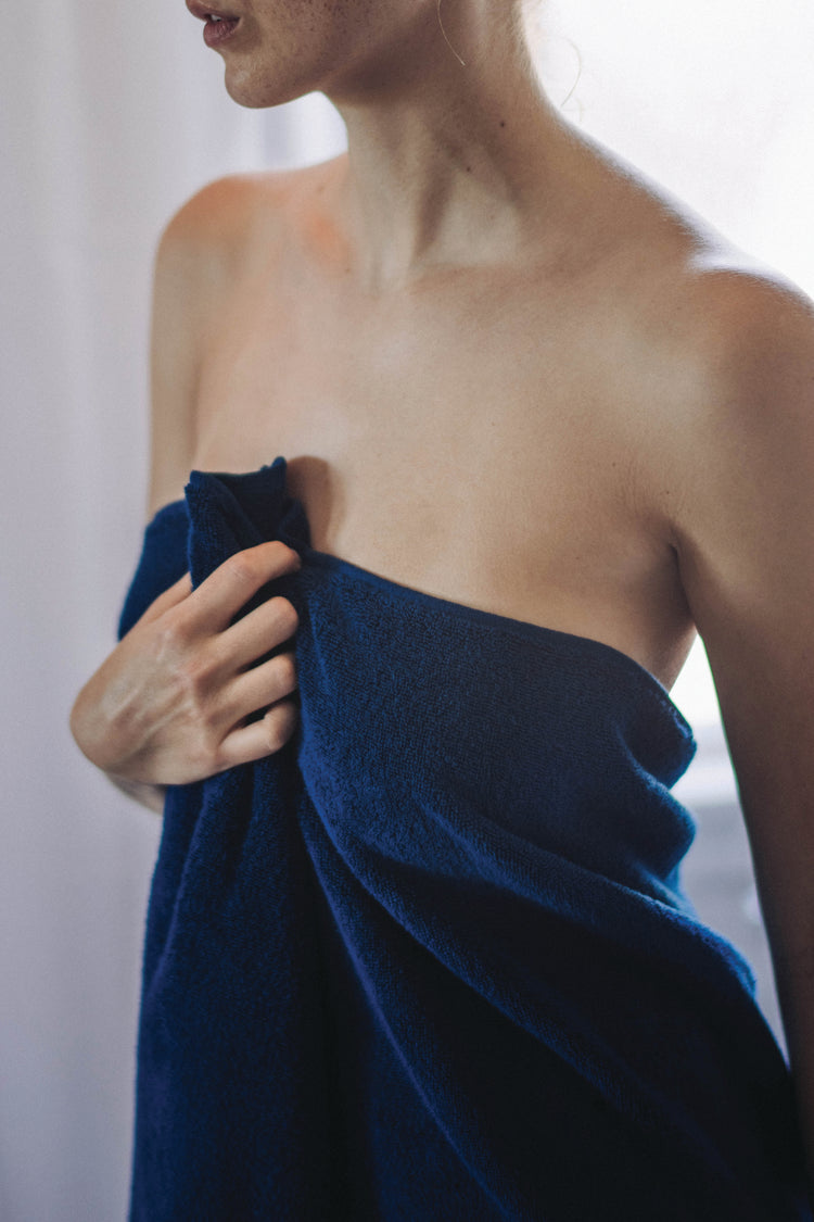 Person wrapped in a blue towel with a blurred background