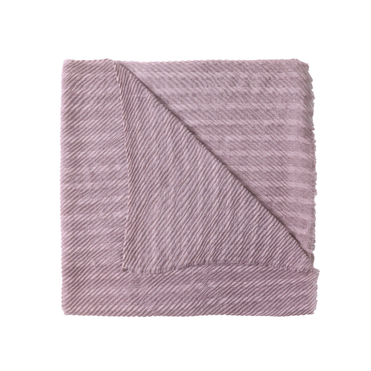 Folded pink textured blanket on a white background