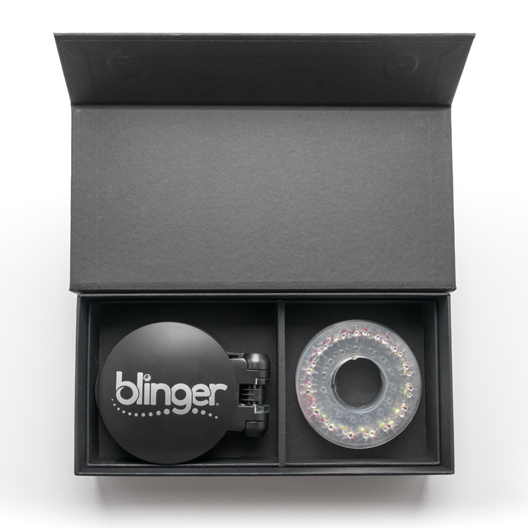 A blinger Vanity Starter Set with a styling tool and a circle of precision-cut glass crystals inside a deluxe black vanity storage case.