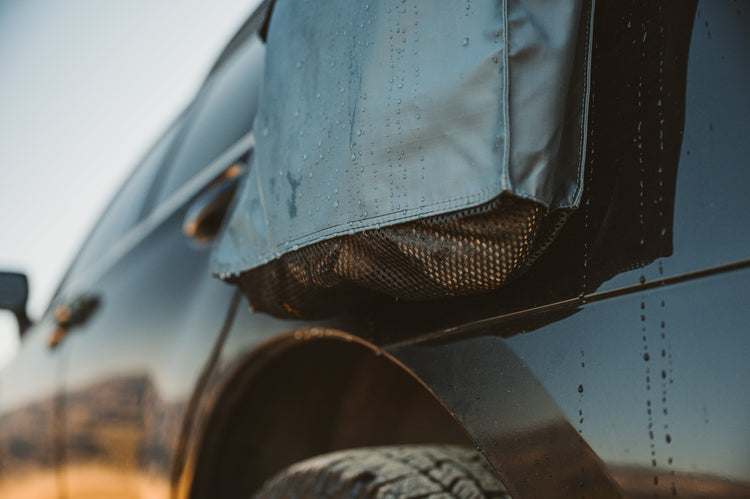 Close-up of a vehicle's side mirror and tire with a blurred background