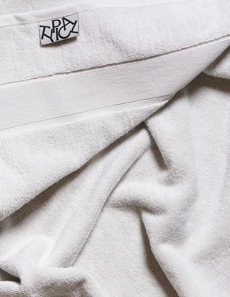 Close-up of white fabric with a brand label on a light background