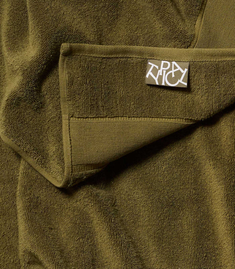 Close-up of a green towel with a brand label on it