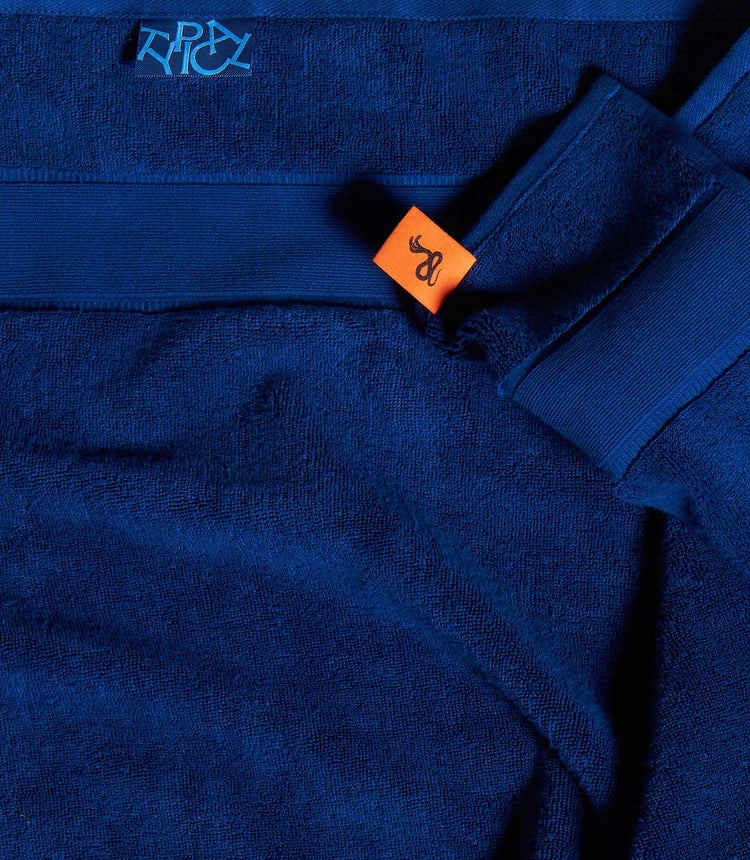 Close-up of a blue garment with a brand logo on an orange tag.