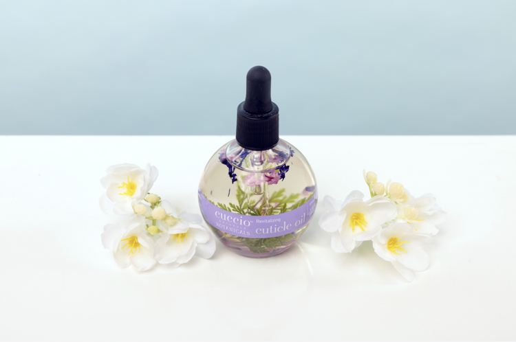 Bottle of essential oil with floral design on a light background
