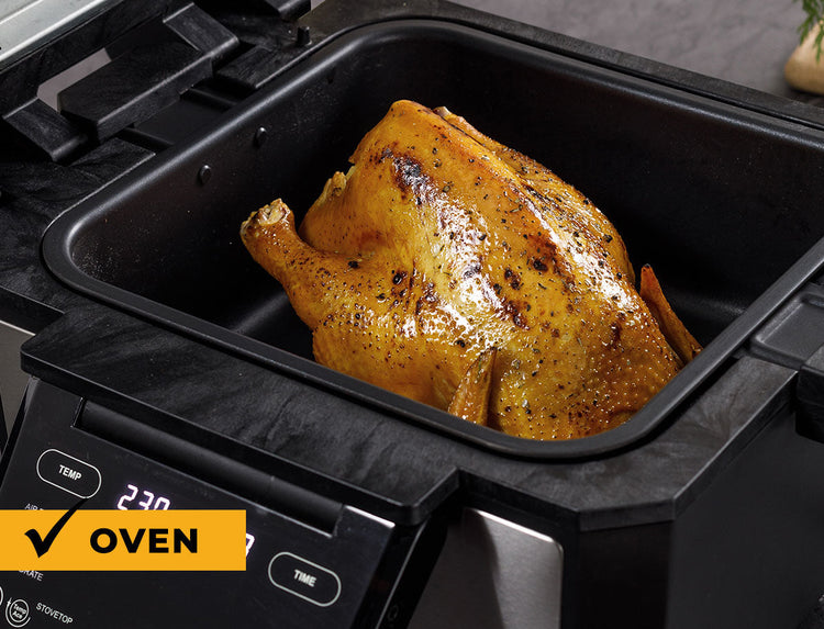 Roasted chicken in an oven with digital display showing temperature.