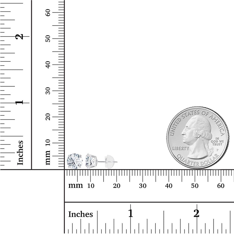 Small silver earrings next to a ruler and a quarter for size reference
