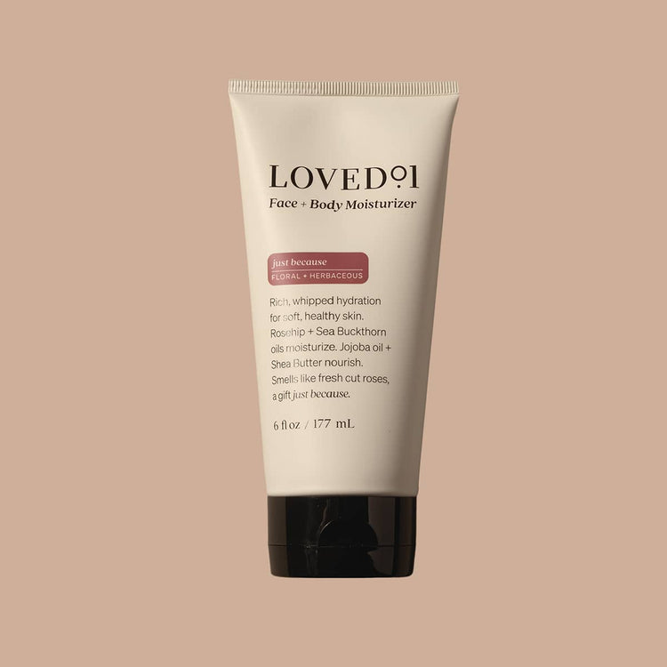 Tube of LOVED11 Face & Body Moisturizer on a beige background