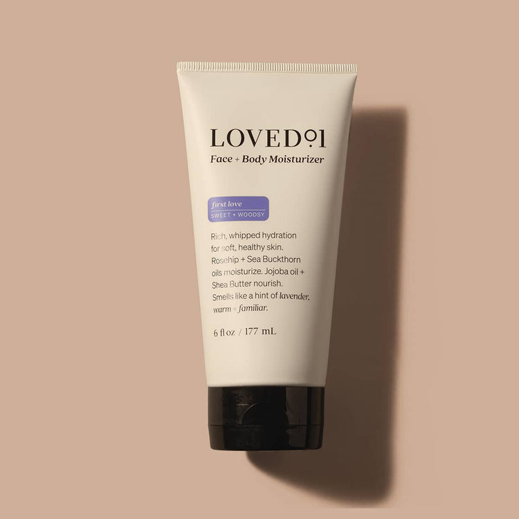 Tube of Loved11 Face + Body Moisturizer on a beige background