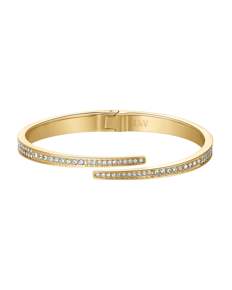 Gold bracelet with diamond accents on a green background