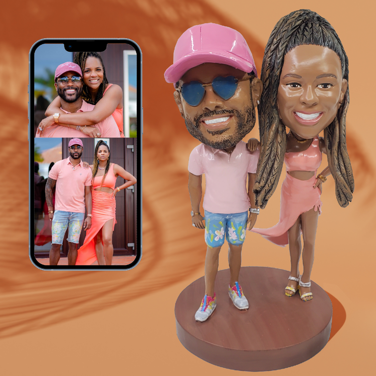 Bobblehead figures of a couple with matching outfits, inspired by a smartphone screen showing a photo of the same couple.