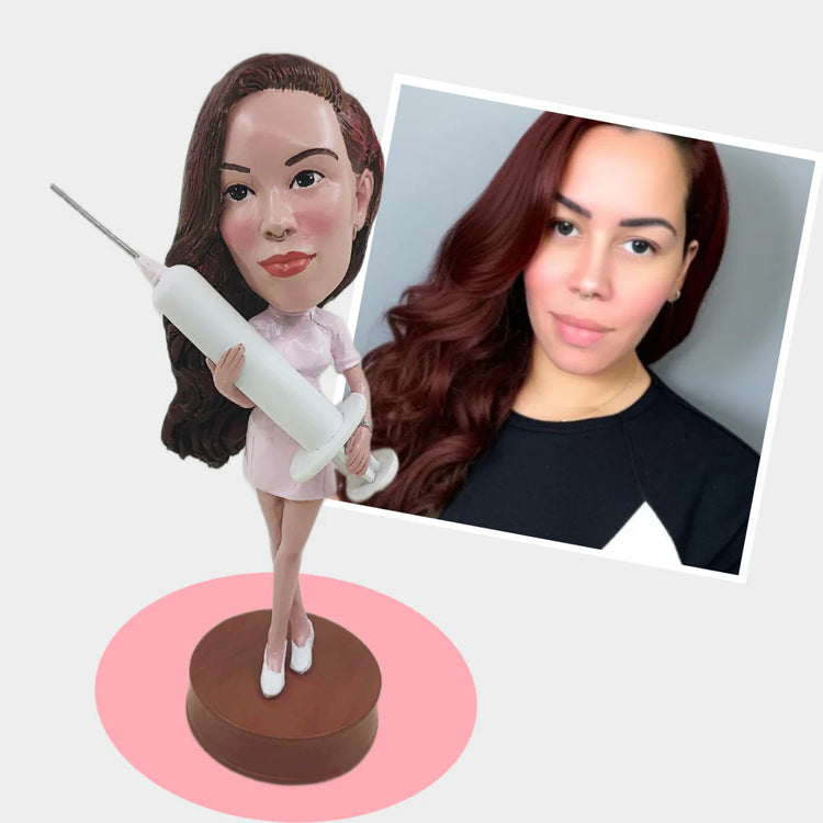 Bobblehead of a woman holding a syringe next to a photo of a real woman with brown hair.