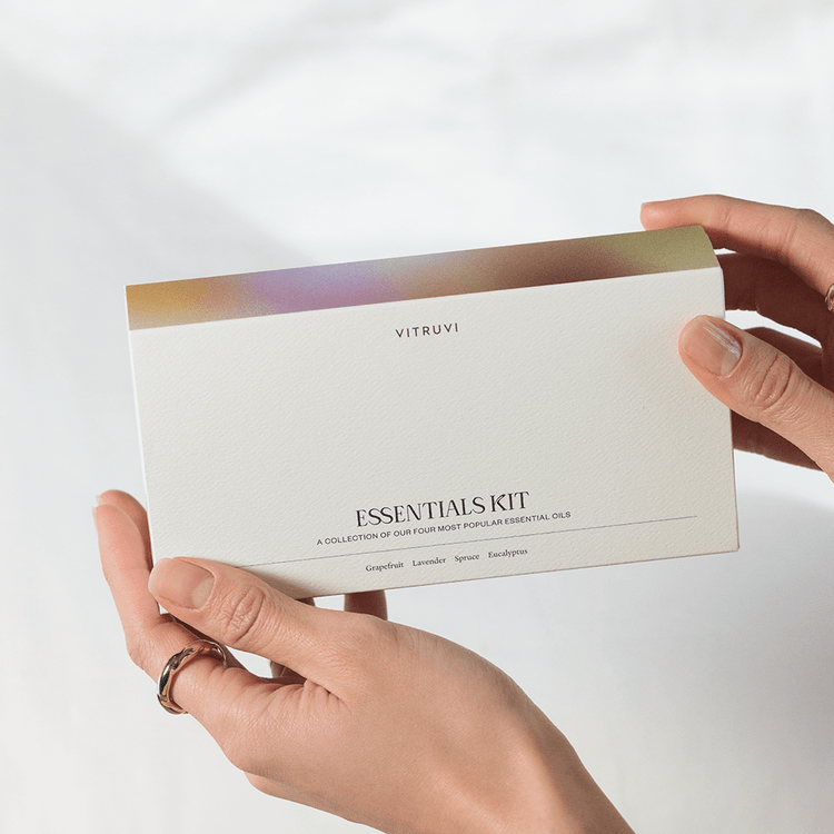 Person holding a Vitruvi Essentials Kit against a light background