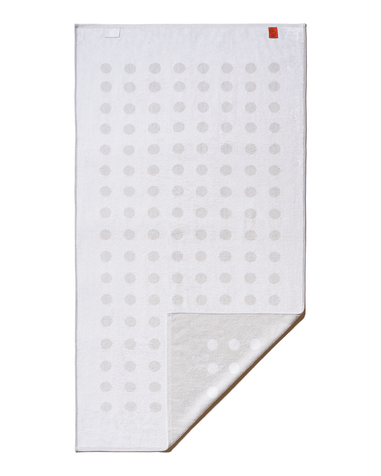 White towel with gray polka dots on a black background