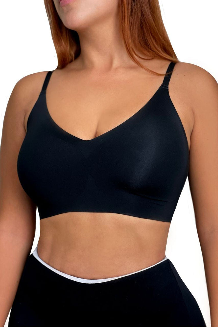 A model wears a black bra and pants against a white background. The front of the bra is displayed.