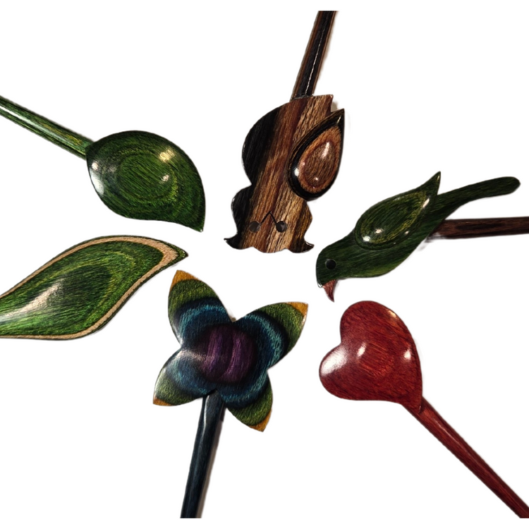 Decorative hair sticks with floral and heart designs on a white background