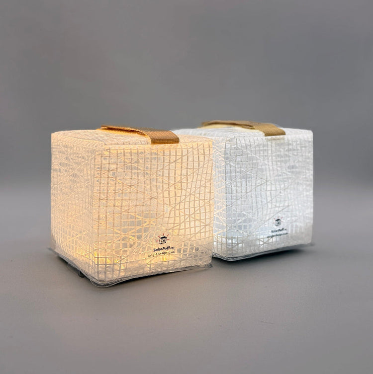 Two SolarPuff lanterns in studio, showing warm and bright white hybrid light settings