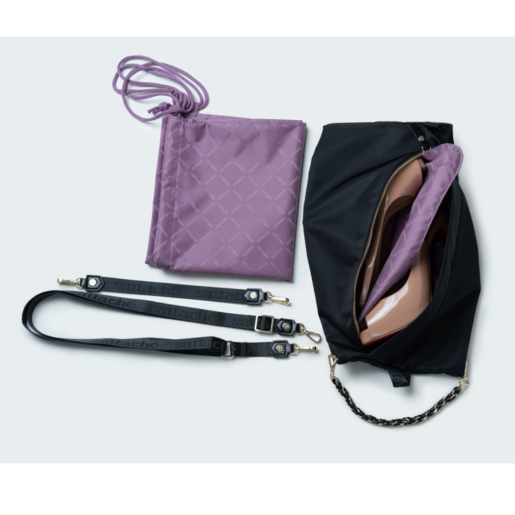 Black bag with pink shoe, purple lining, and black strap on a light gray background