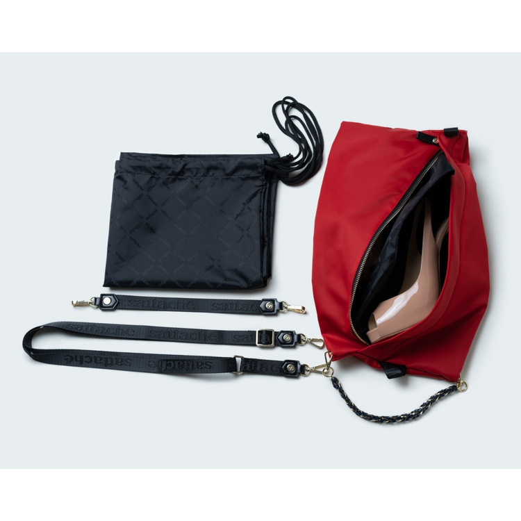 Red drawstring bag with black straps on a light gray background