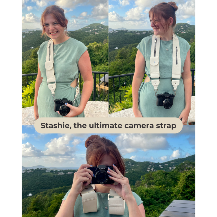 Woman holding a camera with a strap, surrounded by scenic views.