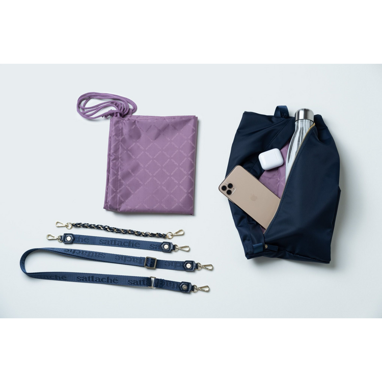 Purple quilted pouch, navy drawstring bag, phone, white mouse, and silver bottle on a light gray background.