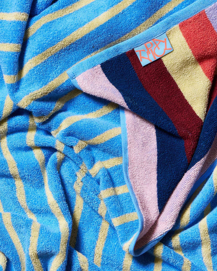 Colorful towel with a brand tag featuring blue, red, and pink stripes.