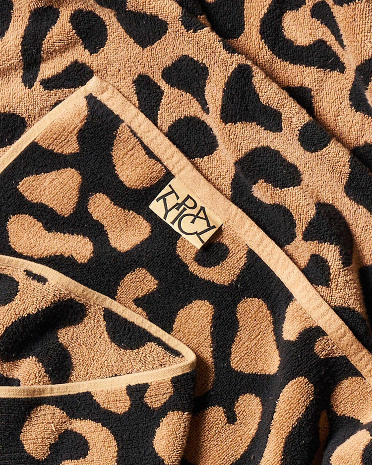 Leopard print towel with a brand logo on a beige background