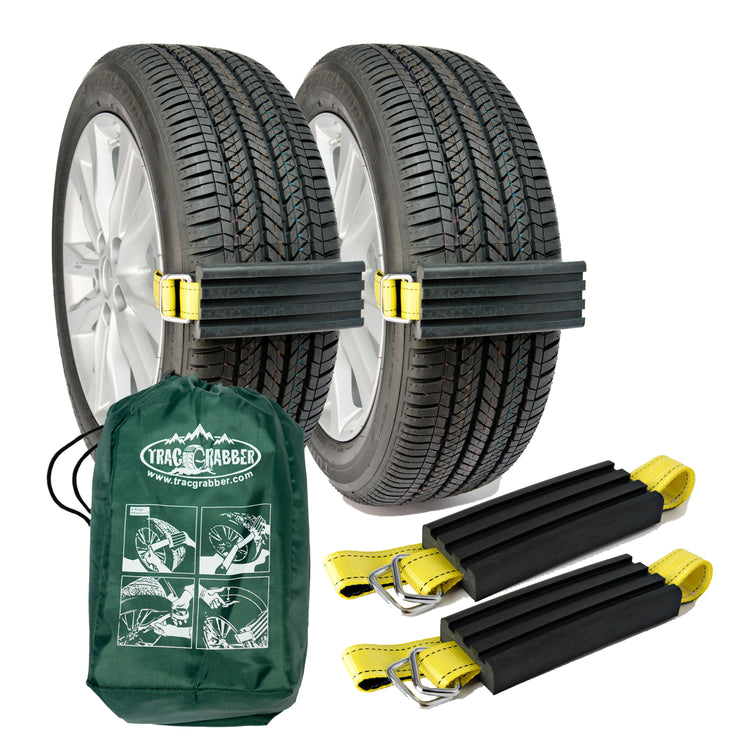 A set of two Trac-Grabber Extreme Traction devices attached to vehicle wheels, with a green storage tote bag displayed in front.