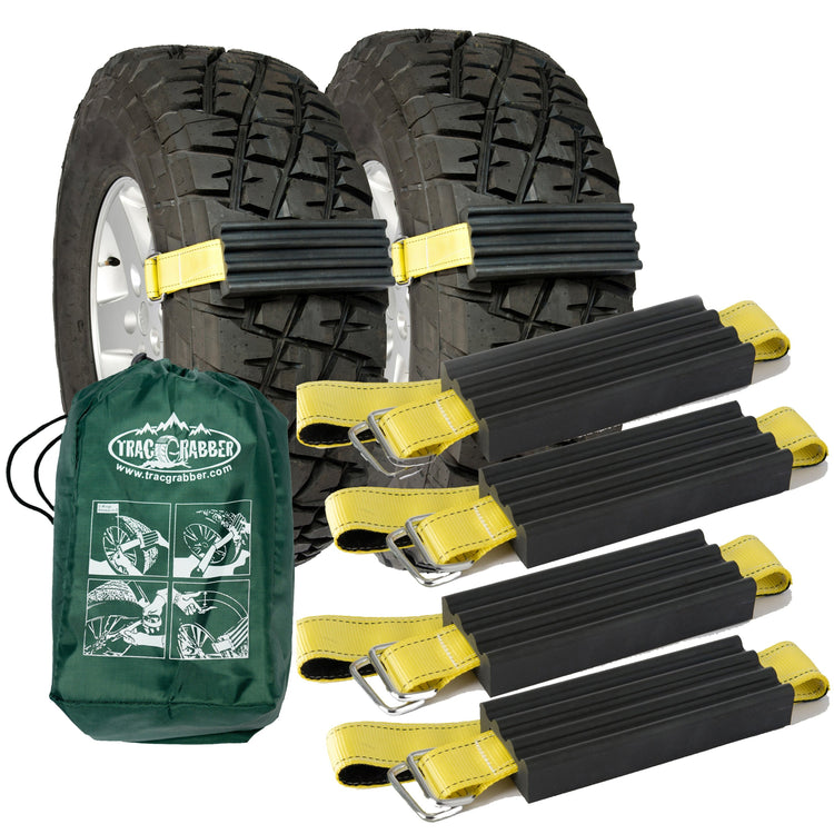 A set of four black Trac-Grabber devices designed for vehicle traction, along with a green storage tote bag. The devices are intended for use on the wheels of trucks and large SUVs to enable easy traction and removal from sticky situations.