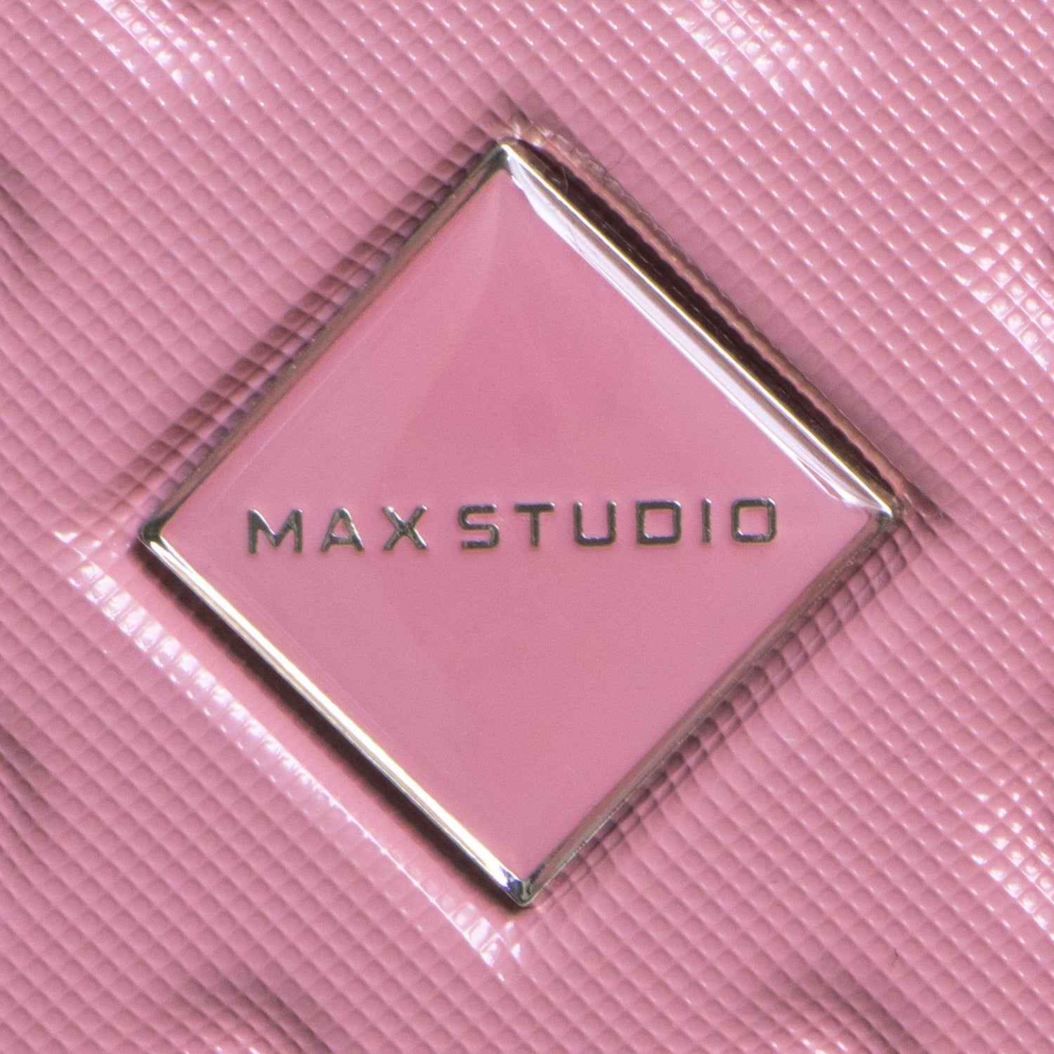 Close-up of a pink product with 'MAX STUDIO' logo on a pink background