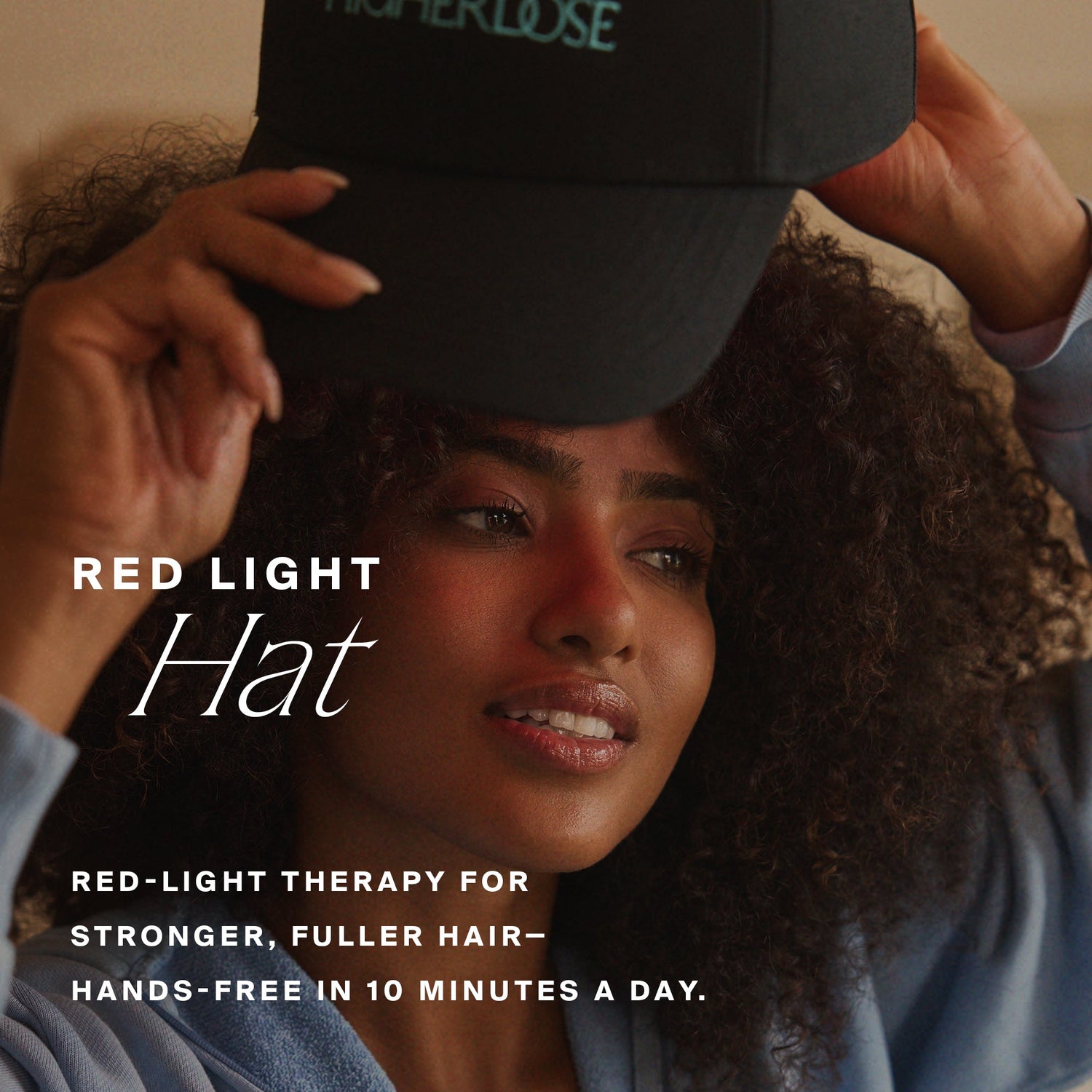 Person wearing a black cap with text about red-light therapy for hair growth.