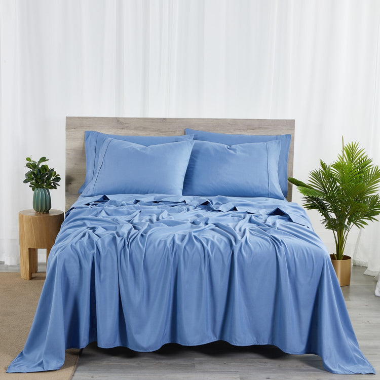 A set of ocean blue bamboo sheets displayed on a bed, including a fitted sheet, a flat sheet, and pillowcases.