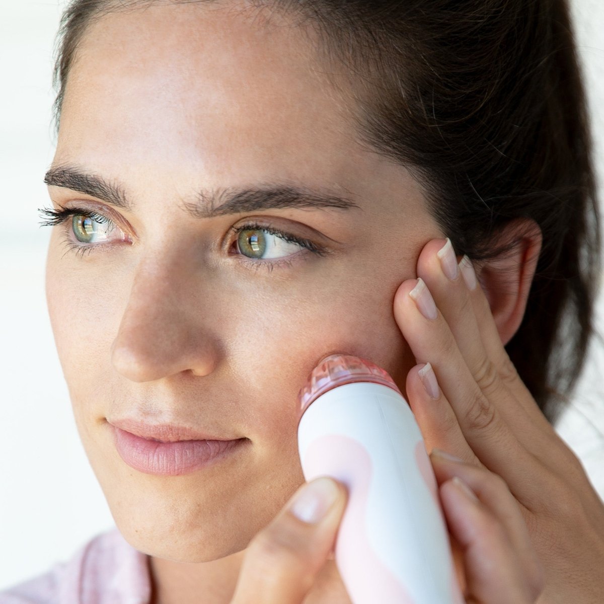 Woman using a skincare device on her face