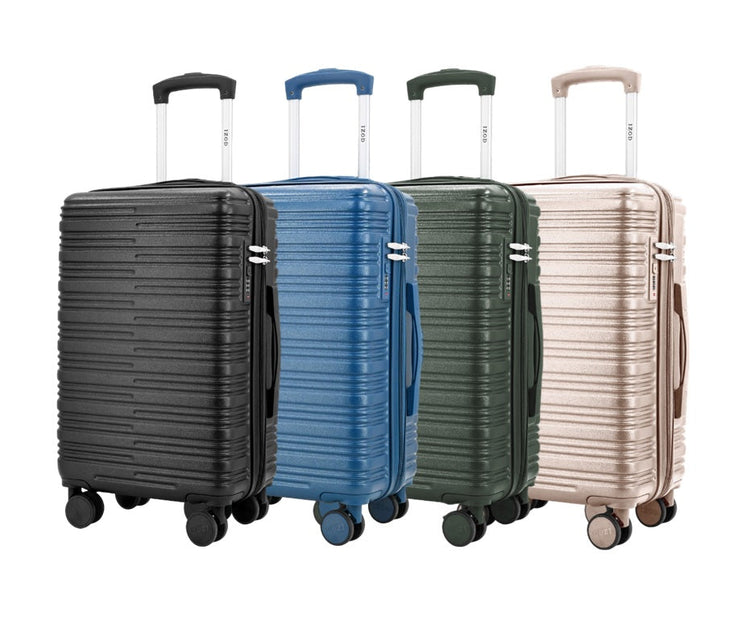 Four suitcases in black, blue, green, and beige on a white background