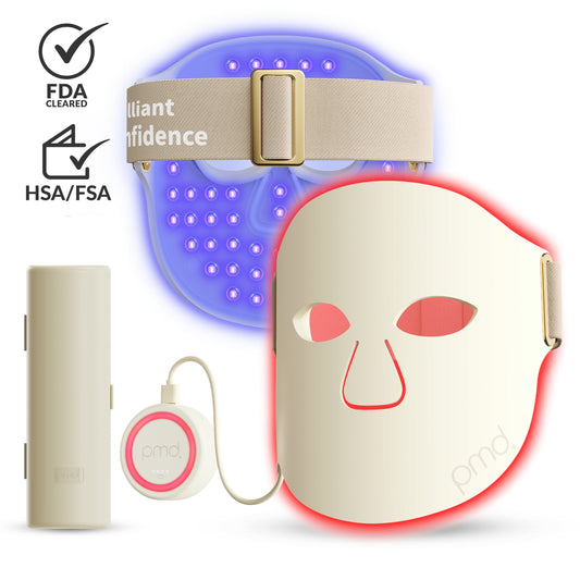 PMD light therapy beauty device kit featuring a red light face mask, blue light headband, cylindrical power bank, and a small round controller, shown on a white background with FDA and HSA/FSA certification icons.