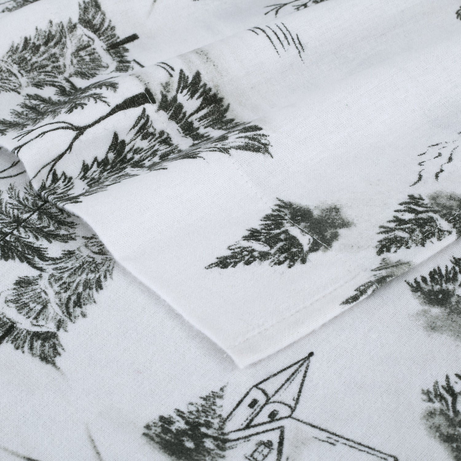 White fabric with black tree and cabin pattern