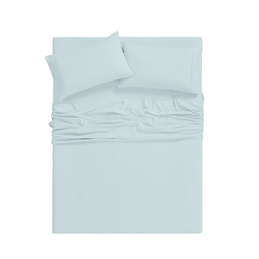 Teal bedding set on a bed in a bright room with large windows.