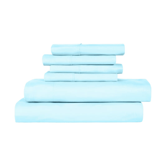 Light blue bedding set on a bed in a room with large windows.