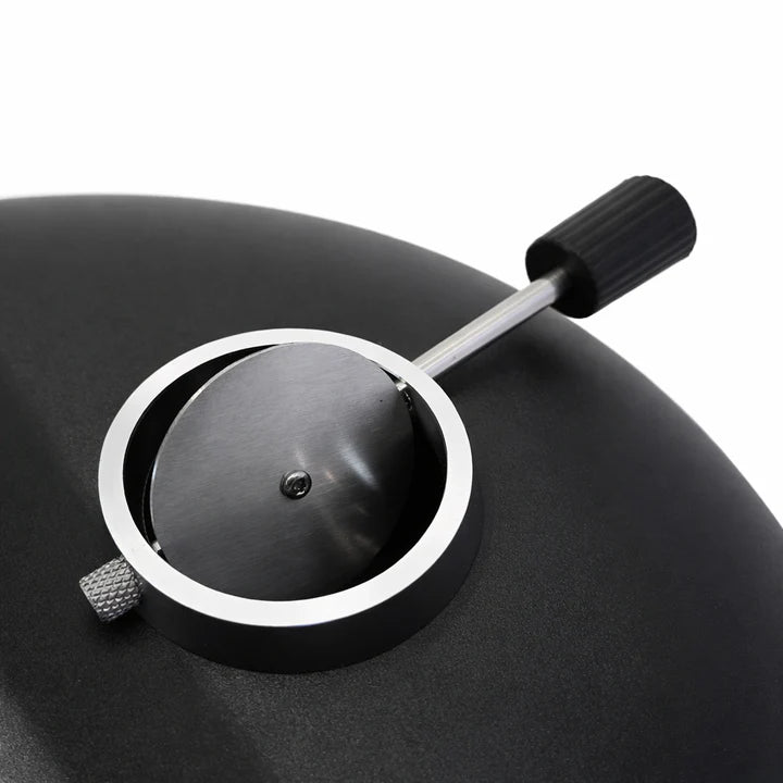 Close-up of a black pressure cooker with a pressure release valve on a white background