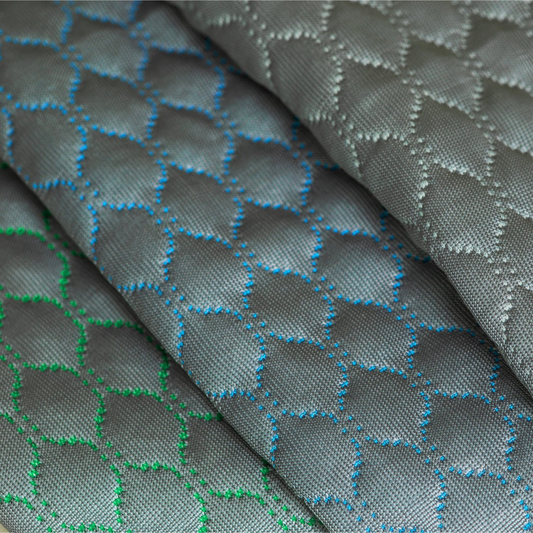 Close-up of textured fabric with geometric pattern and color variations.