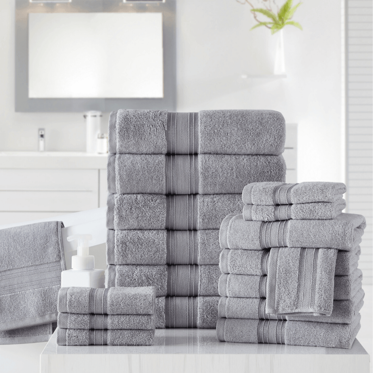 Stack of gray towels with striped patterns on a bathroom counter.
